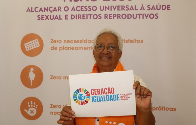 Legenda: Idalinda Rodrigues da Rede Mulher Angola, com o cartaz #geraçaoigualdade 