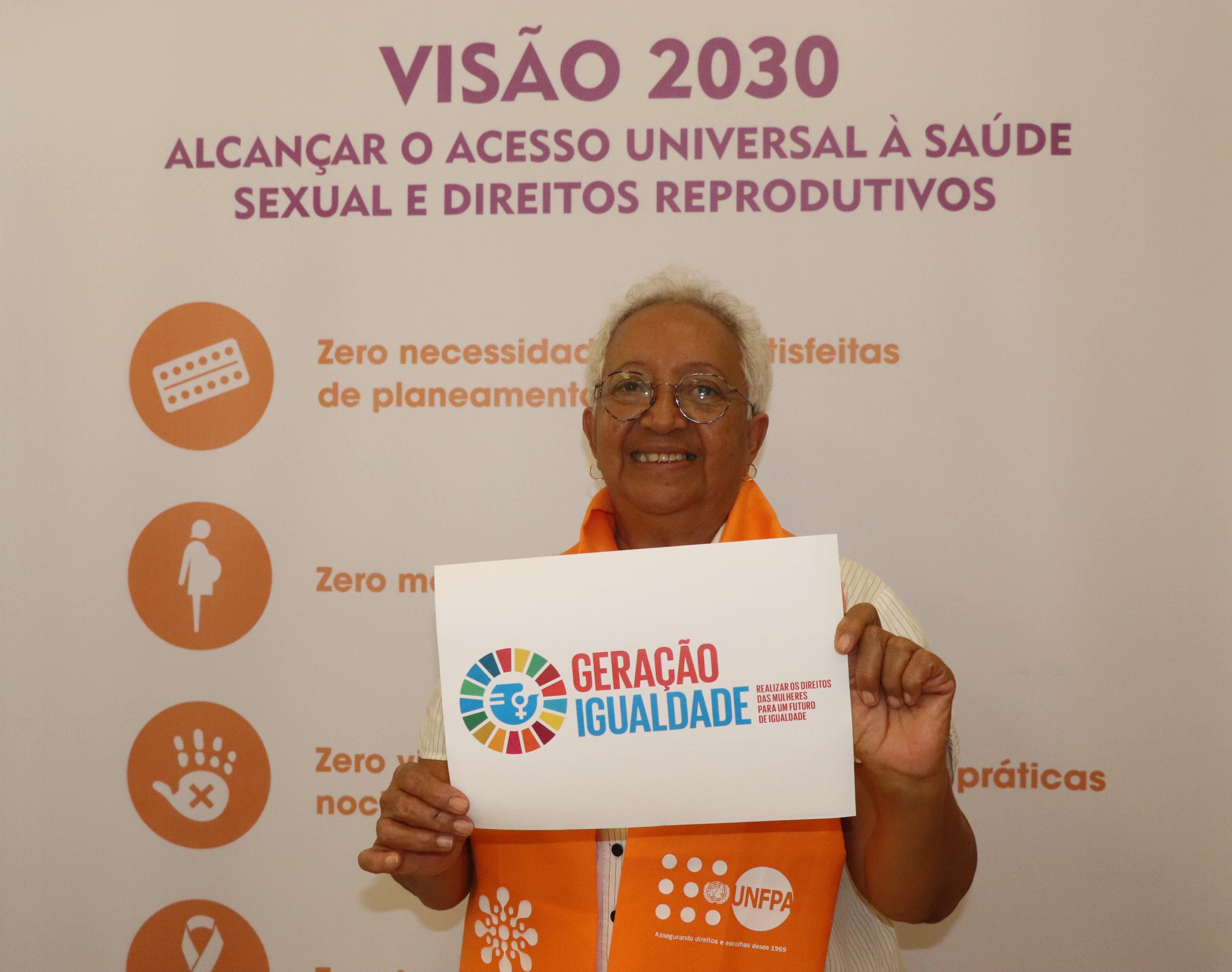 Legenda: Idalinda Rodrigues da Rede Mulher Angola, com o cartaz #geraçaoigualdade 